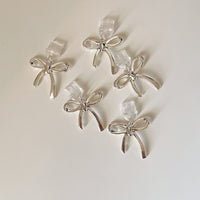 close-up of silver kindle bow charms dust plug charms for kindle or e-reader and phone